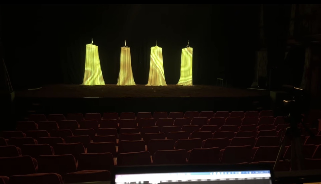 Salle et scène de Dernier Souffle avec quatre volumes verticaux recevant les projections